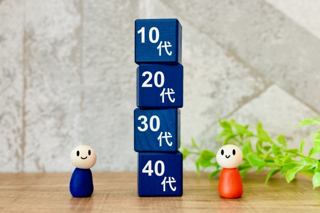 縦に積まれている、10代、20代、30代、40代と書いてあるブロックと木の人形
