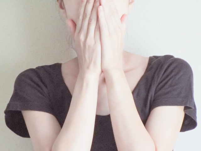 両手で口を覆っている女性