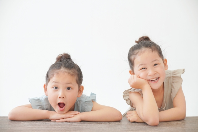 テーブルのよりかかる双子の姉妹