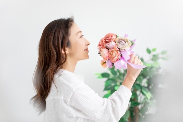 ピンクのバラの花束を持っている女性の横顔