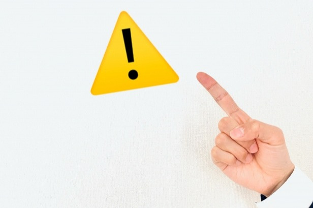 注意マークを指さしている手